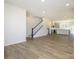 Large living room with hardwood floors, staircase, and kitchen view at 3904 Craig Ave, Charlotte, NC 28211