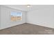Sunlit bedroom featuring a carpeted floor and a window offering a pleasant view at 451 Lookout Dam Rd, Statesville, NC 28625