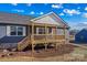 Lovely covered front porch with wood railings and stairs on a home with blue siding at 451 Lookout Dam Rd, Statesville, NC 28625
