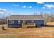 Back of the house with a gray roof, blue siding, and a small wooden deck at 451 Lookout Dam Rd, Statesville, NC 28625