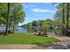 Backyard with a gazebo by the lake with mature trees and blue skies at 4786 Heather Ln, Denver, NC 28037