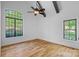 Bright, airy bedroom with hardwood floors, large windows with black trim, and a ceiling fan at 4786 Heather Ln, Denver, NC 28037