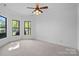 Bright bedroom featuring plush carpeting, white walls, ceiling fan, and large windows with lake views at 4786 Heather Ln, Denver, NC 28037