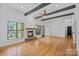 Spacious living room with a stone fireplace, beamed ceilings, and scenic water view at 4786 Heather Ln, Denver, NC 28037