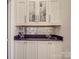 Elegant bar area with glass door cabinets, granite countertops, and mirrored backsplash at 503 Stuart Rdg, Cramerton, NC 28032