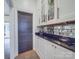 Stylish bar area with granite countertops, mirrored backsplash, and custom cabinets perfect for entertaining at 503 Stuart Rdg, Cramerton, NC 28032