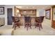 Basement bar featuring wood paneling, brick accents, seating for three, and decorative lighting and shelving at 503 Stuart Rdg, Cramerton, NC 28032