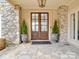 Elegant stone entryway with double doors, decorative plants, and a stone patio at 503 Stuart Rdg, Cramerton, NC 28032