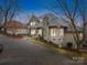 Stately home featuring a stone chimney and accents, complimented by a circular driveway and mature trees at 503 Stuart Rdg, Cramerton, NC 28032