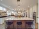 Bright kitchen with a large marble island, modern lighting, wine cooler, and stainless steel appliances at 503 Stuart Rdg, Cramerton, NC 28032