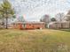 Exterior backyard with a red brick home, a back deck, and a very big grassy yard at 608 E Matthews St, Matthews, NC 28105