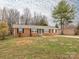 Charming brick home featuring a manicured lawn, black shutters and a brightly painted front door at 608 E Matthews St, Matthews, NC 28105