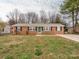 Charming brick home featuring a manicured lawn, black shutters and a brightly painted front door at 608 E Matthews St, Matthews, NC 28105