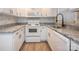Well-lit kitchen featuring white cabinets, granite countertops, stainless steel appliances, and backsplash at 608 E Matthews St, Matthews, NC 28105