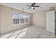 A neutral-toned bedroom featuring a large window and a ceiling fan at 9724 Walkers Glen Nw Dr, Concord, NC 28027