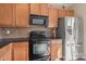 Classic kitchen featuring wood cabinets, stainless steel appliances, and neutral backsplash at 9724 Walkers Glen Nw Dr, Concord, NC 28027