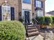 Close-up of the front entrance with black door, festive wreath, and manicured shrubs at 9906 Mitchell Glen Dr, Charlotte, NC 28277