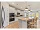 Bright kitchen features stainless steel appliances, including double ovens, and a large island with stone countertops at 1029 Dali Blvd, Mount Holly, NC 28120