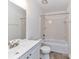 Bathroom featuring a vanity, toilet, and bathtub with shower and tiled walls at 11020 Carmel Crossing Rd, Charlotte, NC 28226