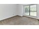 Clean bedroom with carpet, a large window, and a neutral color palette at 11020 Carmel Crossing Rd, Charlotte, NC 28226