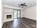Bright living room featuring sleek floors, brick fireplace and sliding doors to the outside at 11020 Carmel Crossing Rd, Charlotte, NC 28226