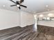 Open living room featuring modern flooring, a ceiling fan, and a pass-through to the kitchen at 11020 Carmel Crossing Rd, Charlotte, NC 28226