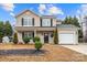 Charming two-story home with light siding, black shutters, well-manicured landscaping and an attached garage at 130 Valley Glen Dr, Troutman, NC 28166