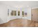 Bright living room boasts hardwood floors, large windows, elegant chandelier and a sliding glass door to the outside at 130 Valley Glen Dr, Troutman, NC 28166
