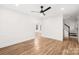 Open-concept living room with hardwood floors, neutral walls, and an open staircase to the second floor at 130 Valley Glen Dr, Troutman, NC 28166