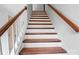 Staircase featuring wood treads, white risers, and stained handrail, creating a classic design at 130 Valley Glen Dr, Troutman, NC 28166