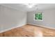 A bedroom with hardwood floors and a window overlooking the trees at 141 Baywatch Dr, Mooresville, NC 28117