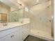 Bright bathroom featuring a double vanity with quartz countertops and a glass-enclosed shower with marble-style tile at 17021 Malone Ln, Mint Hill, NC 28227