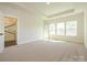 Sunlit bedroom with carpeted floors, tray ceiling, and an ensuite bathroom featuring a glass-enclosed shower at 17021 Malone Ln, Mint Hill, NC 28227