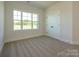 Bright bedroom with neutral carpet, large window view and closet with paneled double doors at 17021 Malone Ln, Mint Hill, NC 28227