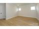Bright bedroom features hardwood floors, white trim, and two windows offering natural light at 17021 Malone Ln, Mint Hill, NC 28227