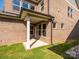 Back porch exterior featuring brick, a covered porch, and a small yard at 17021 Malone Ln, Mint Hill, NC 28227