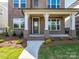 Inviting front porch with brick supports, stone walkway, and manicured landscaping at 17021 Malone Ln, Mint Hill, NC 28227