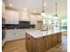 Bright kitchen featuring an island, white cabinets, modern backsplash, and pendant lights at 17021 Malone Ln, Mint Hill, NC 28227