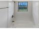 Bathroom with white tiled walls, a tub/shower combo and a window at 207 Bright Ave, Bessemer City, NC 28016