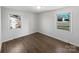 Bright bedroom with hardwood floors, neutral paint, and natural light from two windows at 207 Bright Ave, Bessemer City, NC 28016