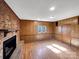 Cozy living room features a brick fireplace, wood-paneled walls, and ample natural light at 207 Bright Ave, Bessemer City, NC 28016