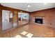Bright living room with a brick fireplace, wood paneling, and an open doorway to another room at 207 Bright Ave, Bessemer City, NC 28016