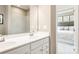 Bathroom featuring double sinks, a large mirror, white cabinets, and an open doorway to the bedroom at 2159 Primm Farms Dr # C, Charlotte, NC 28216