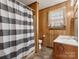 Retro bathroom featuring wood paneling, patterned shower curtain, and window at 3204 Starrland Dr, Gastonia, NC 28052
