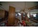Dining area with wood paneling and vintage chandelier, adjacent to the kitchen for convenient meal service at 351 York Spann Rd, Hamptonville, NC 27020