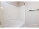 White bathroom with tub and shower, light walls, and black towel rack at 7725 Petrea Ln, Charlotte, NC 28227