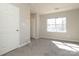 Neutral carpeted bedroom with closet, window, and door at 7725 Petrea Ln, Charlotte, NC 28227
