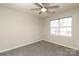 Bright, neutral-toned bedroom with ceiling fan, window, and carpeted floor at 7725 Petrea Ln, Charlotte, NC 28227