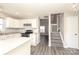 Open concept kitchen with stainless steel appliances, grey tone flooring, and easy access to the staircase and living room at 7725 Petrea Ln, Charlotte, NC 28227