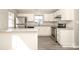 Updated kitchen with stainless steel appliances, white cabinetry, grey tone flooring and a breakfast bar at 7725 Petrea Ln, Charlotte, NC 28227
